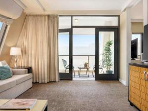a living room with a couch and a view of the ocean at Hotel Sofitel Los Angeles at Beverly Hills in Los Angeles