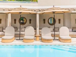 a pool with chairs and tables and umbrellas at Hotel Sofitel Los Angeles at Beverly Hills in Los Angeles