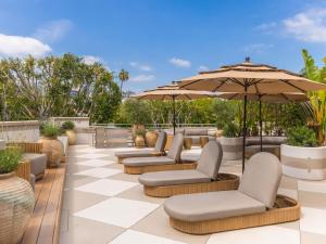 a patio with chairs and umbrellas on a checkered floor at Hotel Sofitel Los Angeles at Beverly Hills in Los Angeles