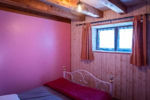 a bedroom with a pink wall with a bed in it at la bergerie in Mialanes