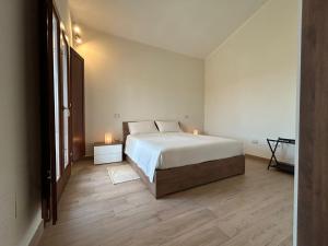 a bedroom with a bed and two candles on the floor at Casa Tanca Marchese in Marrùbiu