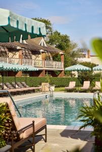 a swimming pool with benches and a house at Faraway Sag Harbor in Sag Harbor