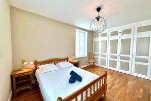 a bedroom with a bed with a blue bag on it at Maison de charme - Jardin - BBQ - 10min du Crotoy in Rue