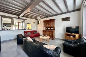 a living room with leather couches and a television at Maison de charme - Jardin - BBQ - 10min du Crotoy in Rue +28 photos