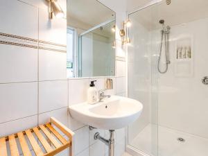 a white bathroom with a sink and a shower at Aqua Sands #1 - Stay Waiheke in Oneroa