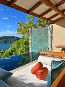 a balcony with a bed and a view of the water at Casa Chameleon Hotel Las Catalinas - Adults Only in Playa Flamingo