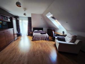 a living room with a bed and a couch at Szary odpoczynek na piętrze - wieś Pogórze, dla zmotoryzowanych in Pogórze