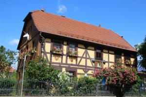 a building with flower boxes and a red roof at Ferienwohnung-Cottage Rhöner Kräute in Buttlar