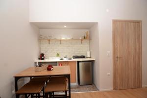 a small kitchen with a table and chairs and a sink at Olympian Kavala in Kavála