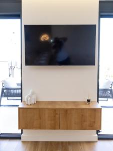 a large flat screen tv on a wall in a living room at Alta Vista House in Bar
