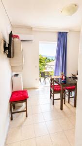 a living room with a table and chairs and a balcony at Louis' apartment with view in Gythio +23 photos