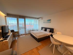 a bedroom with a bed and a table and a tv at Balino 57 in Balatonlelle