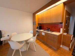 a kitchen with a table and white chairs in a room at Balino 57 in Balatonlelle