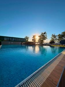 a large swimming pool with the sun setting in the background at Balino 57 in Balatonlelle