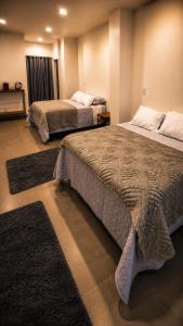 two beds in a room with rugs at Sely Suítes in Ametista do Sul +23 photos