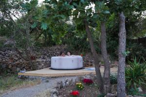 a man sitting in a bath tub in a garden at glamping giardino museo a gisa in Petralia Sottana