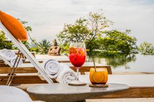 a table with a glass of wine and a drink at Casa Chameleon Hotel Las Catalinas - Adults Only in Playa Flamingo