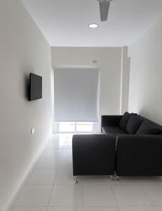 a living room with a black couch and a television at Departamento in Formosa