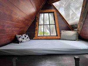 a large bed in a room with a window at Private Beachfront Beach Hut in Manzanillo
