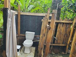 a bathroom with a toilet and a wooden fence at Private Beachfront Beach Hut in Manzanillo +30 photos