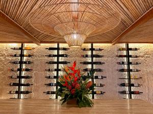 a vase of flowers on a table in front of a wine cellar at Casa Chameleon Hotel Las Catalinas - Adults Only in Playa Flamingo