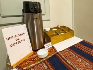 a thermos and a box on a rug with a table at Hotel Qoyllur urcos in Urcos