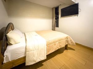 a bedroom with a bed and a flat screen tv at Hotel Qoyllur urcos in Urcos
