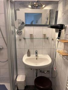 a bathroom with a sink and a shower with a mirror at Ferienwohnung Möwenschiss - Haus Bake in Büsum