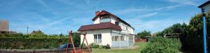 a small white house with a red roof at Willa Madi in Grzybowo