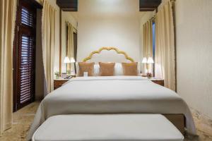 a bedroom with a large white bed and two lamps at Hotel Boutique Santo Toribio in Cartagena de Indias +29 photos