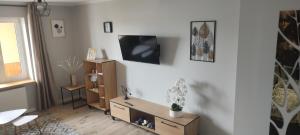 a living room with a tv on a white wall at Willa Madi in Grzybowo