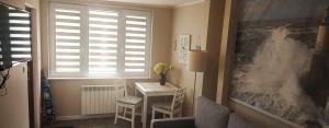 a living room with a desk and a window at Willa Madi in Grzybowo
