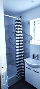 a bathroom with a shower curtain and a sink at Willa Madi in Grzybowo +15 photos