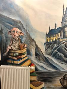 a painting of a man sitting on a pile of books at La Melodia in Kościerzyna