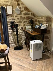 a room with a desk and a computer on the floor at Gîtes d Izel2 entre terre et mer prés d'un golf in Ploemel