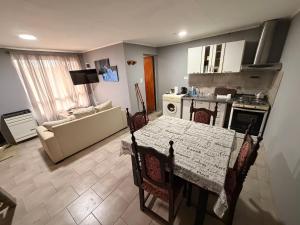 a living room with a table and a kitchen with a couch at Deptos Valen in Trevelín