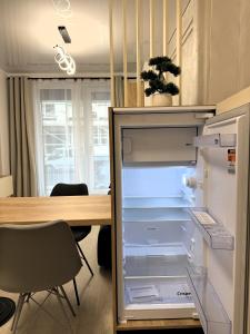 an empty refrigerator with its door open next to a table at VIBE Apartments in Năvodari