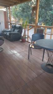 a patio with a couch and a table and chairs at Casa de campo in Colina