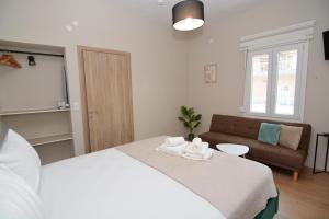 a bedroom with a white bed and a couch at Olympian Kavala in Kavála