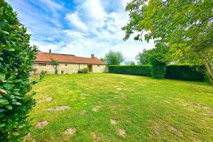 a yard with a house and a hedge at Maison de charme - Jardin - BBQ - 10min du Crotoy in Rue