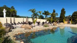 a swimming pool with chairs and umbrellas in a resort at Cabana's Acqua Hotel in Águas de Lindoia