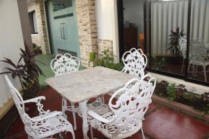 d'une table et de quatre chaises blanches sur un balcon. dans l'établissement Casa Belina, à Puerto Princesa