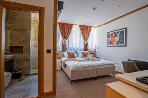 a hotel room with a bed and a bathroom at Vila Hera Spa in Vrbas
