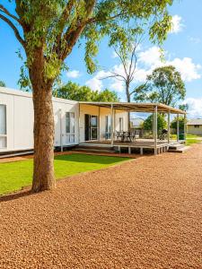a house with a tree in front of it at Gem on Matrix - Hidden Retreat with Deck in Lightning Ridge