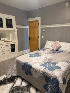 a bedroom with a bed with a blue and white blanket at Rooms at Broadway Booking in Minneapolis