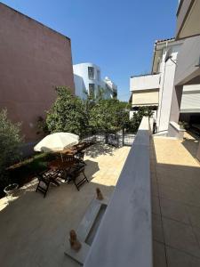 a patio with a table and chairs and an umbrella at Apollonian House in Korinthos