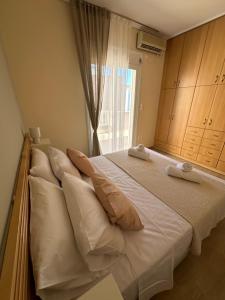a bedroom with a large bed with pillows and a window at Apollonian House in Korinthos