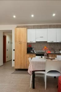 a kitchen with white cabinets and a table and chairs at B&B ombra dei pini in San Leucio del Sannio