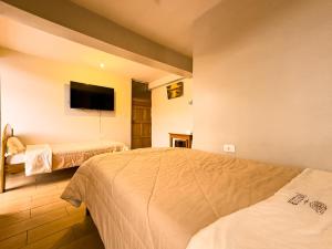 a hotel room with two beds and a flat screen tv at Hotel Qoyllur urcos in Urcos