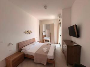 a bedroom with a bed and a television in it at MESSAPIA HOME Apartments in Mesagne +212 photos